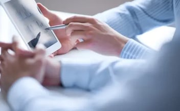 Close-up of hands typing on a tablet.